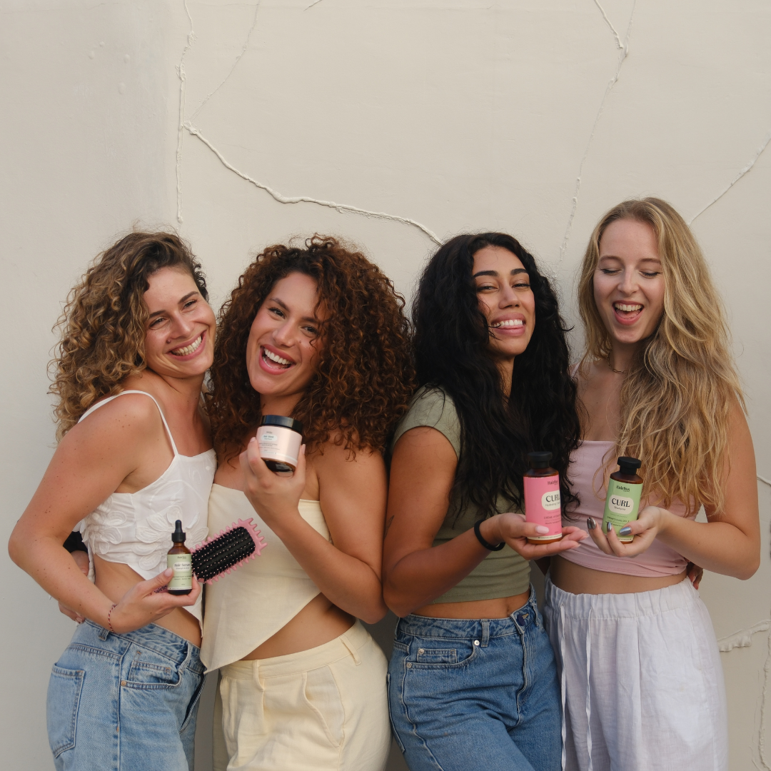 Quatre femmes bouclées tenant les produits Hairliss Image